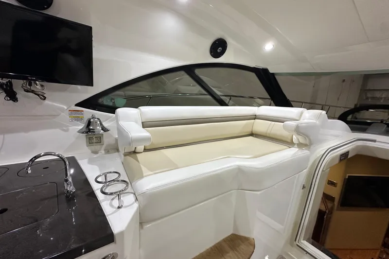 Slide: The Image of Interior of 2014 Sea Ray 410 Sundancer yacht with seating, sink, and TV. - 13