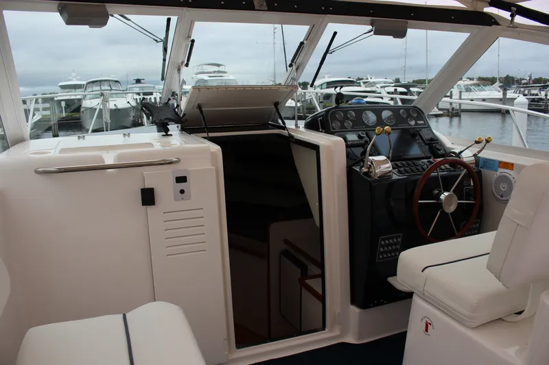 Slide: The Image of 2001 Tiara Yachts 2900 Coronet cockpit with steering wheel and control panel, docked at marina. - 27