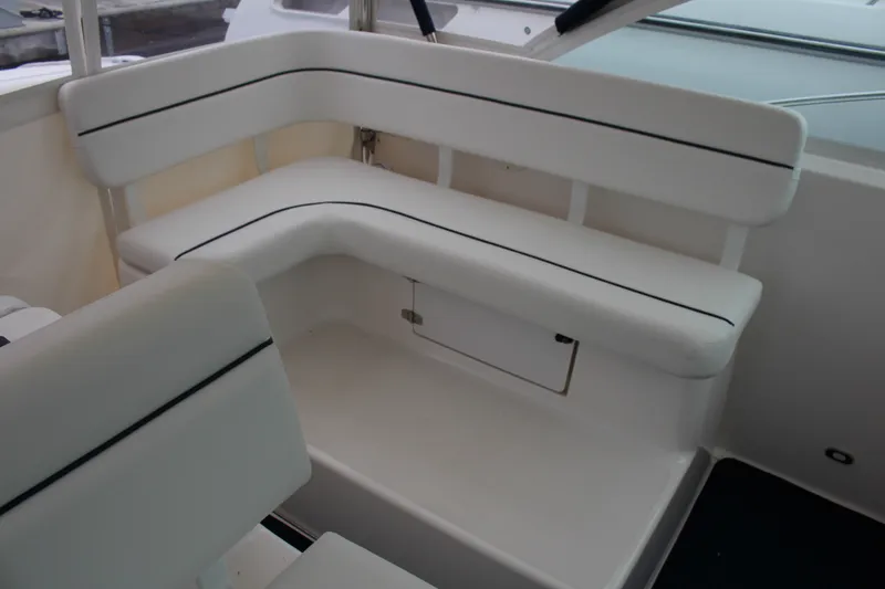 Slide: The Image of 2001 Tiara Yachts 2900 Coronet interior seating with white cushions and storage compartment. - 26