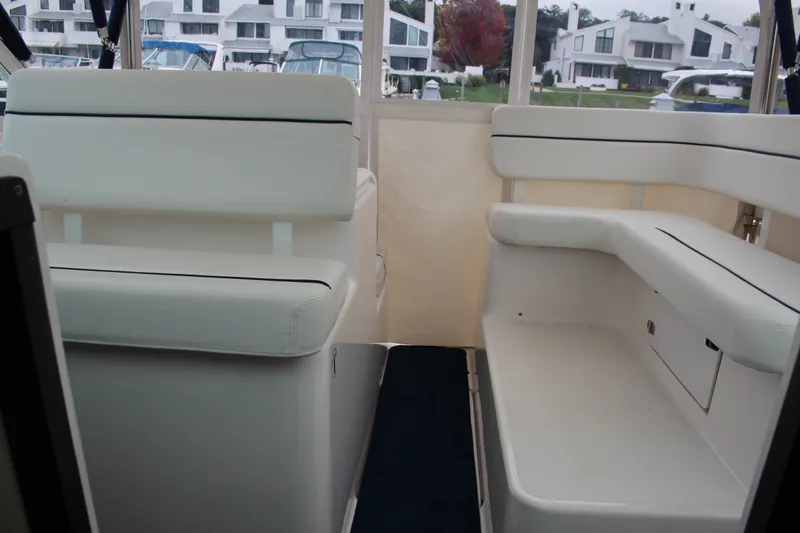 Slide: The Image of Interior seating of 2001 Tiara Yachts 2900 Coronet, featuring white upholstery and marina view. - 19