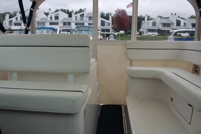 Slide: The Image of Interior view of a 2001 Tiara Yachts 2900 Coronet with white seating and marina backdrop. - 18