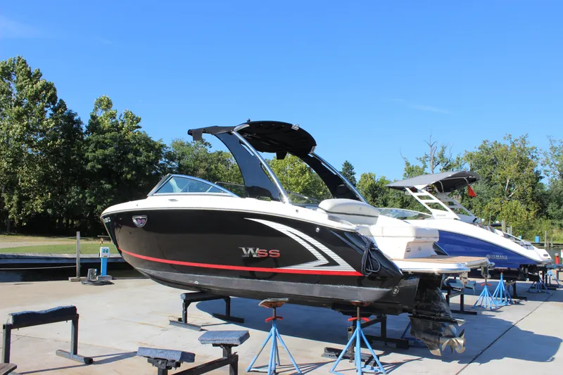 Slide: The Image of 2016 Cobalt R5 WSS boat on stands, outdoors, with trees in the background. - 1