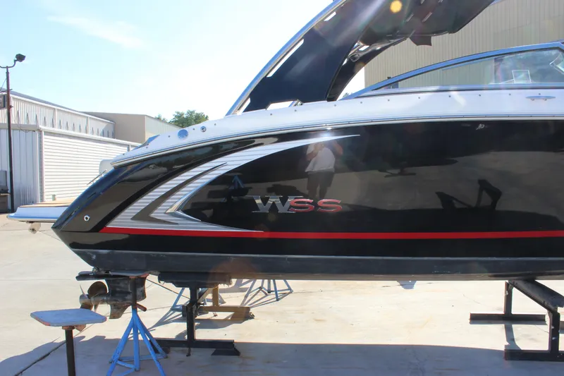 Slide: The Image of 2016 Cobalt R5 WSS boat on stands, black with red accents, in a sunny outdoor setting. - 31