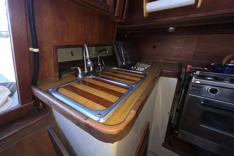 Slide: The Image of 1970 Newport 41 yacht kitchen with wooden countertops and stainless steel sink. - 4