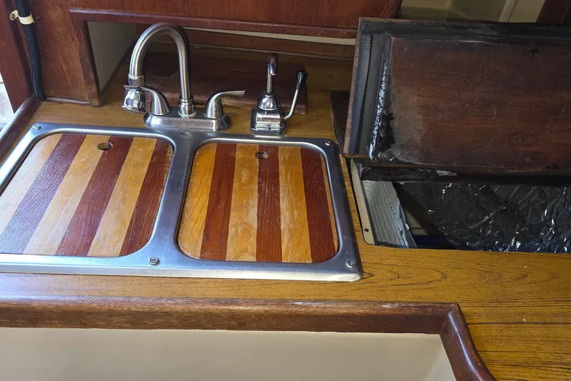 Slide: The Image of 1970 Newport 41 yacht kitchen with wooden countertops and dual sink. - 2