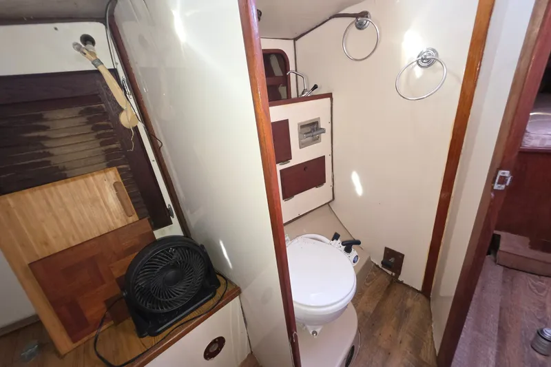 Slide: The Image of Interior of a 1970 Newport 41 sailboat bathroom with wooden accents and compact design. - 7