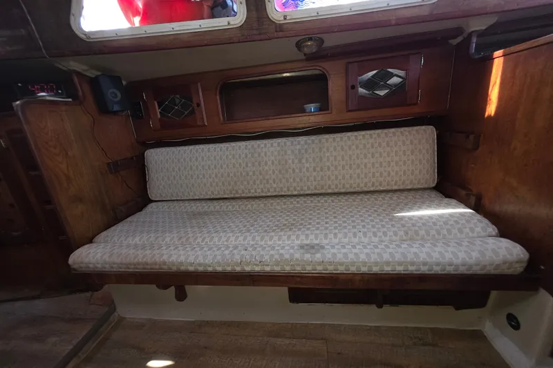 Slide: The Image of Interior of a 1970 Newport 41 sailboat with cushioned seating and wooden cabinetry. - 6