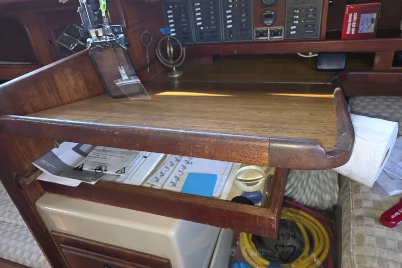 Slide: The Image of Navigation station inside a 1970 Newport 41 sailboat, featuring wooden desk and control panels. - 11