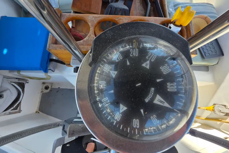 Slide: The Image of Compass on a 1970 Newport 41 sailboat, surrounded by nautical equipment. - 12