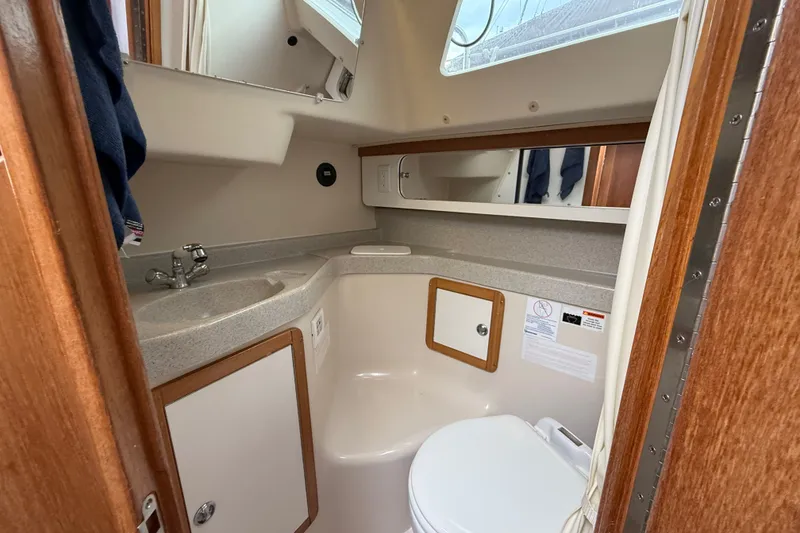 Slide: The Image of Compact bathroom in a 2007 Catalina 34 MkII sailboat, featuring sink, toilet, and mirror. - 64