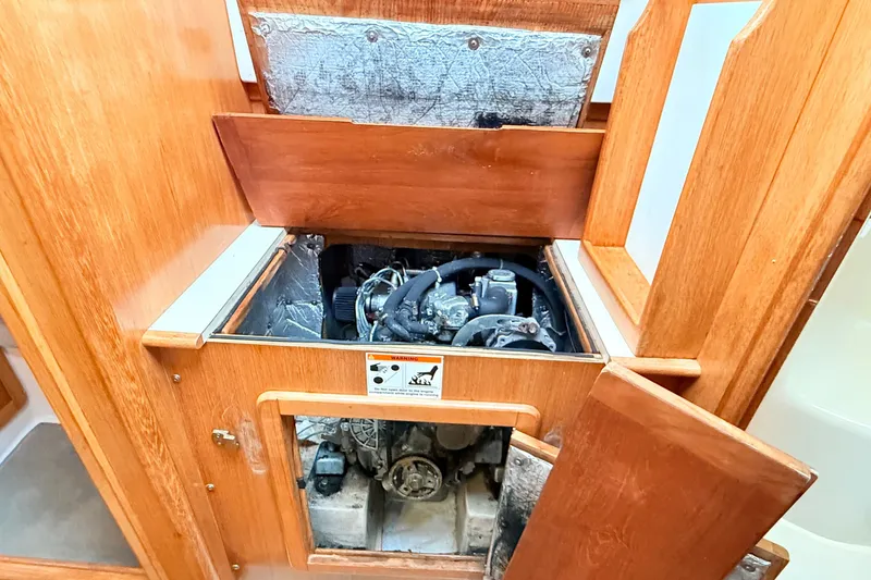 Slide: The Image of Engine compartment of a 2007 Catalina 34 MkII sailboat, showcasing wooden paneling. - 70