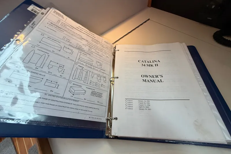 Slide: The Image of Catalina 34 MkII 2007 owner's manual in a blue binder on a desk. - 52