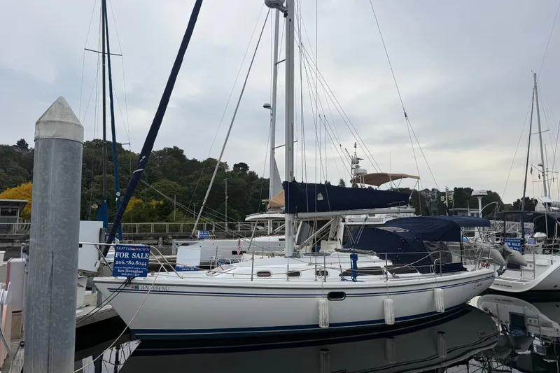 Slide: The Image of 2007 Catalina 34 MkII sailboat docked, for sale, with blue covers and visible masts. - 14