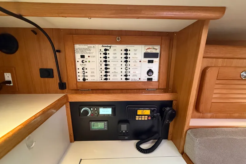 Slide: The Image of Control panel of a 2007 Catalina 34 MkII sailboat, featuring electrical switches and communication equipment. - 49