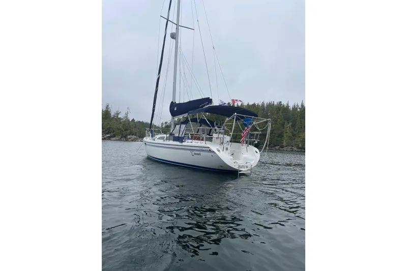 Slide: The Image of Catalina 34 MkII sailboat from 2007 anchored in a serene, forested bay. - 6