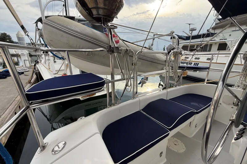 Slide: The Image of 2007 Catalina 34 MkII sailboat cockpit with blue cushions and docked dinghy. - 34