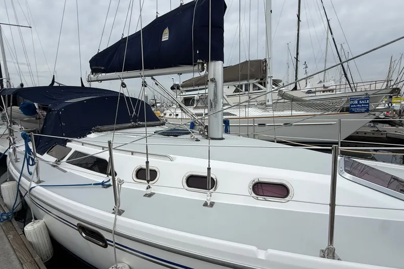 Slide: The Image of 2007 Catalina 34 MkII sailboat docked with blue covers and visible rigging. - 17