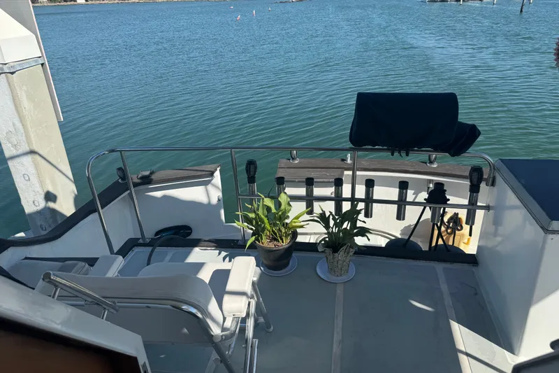 Slide: The Image of Aft deck of 1989 DeFever 54 yacht with chairs and potted plants overlooking water. - 34