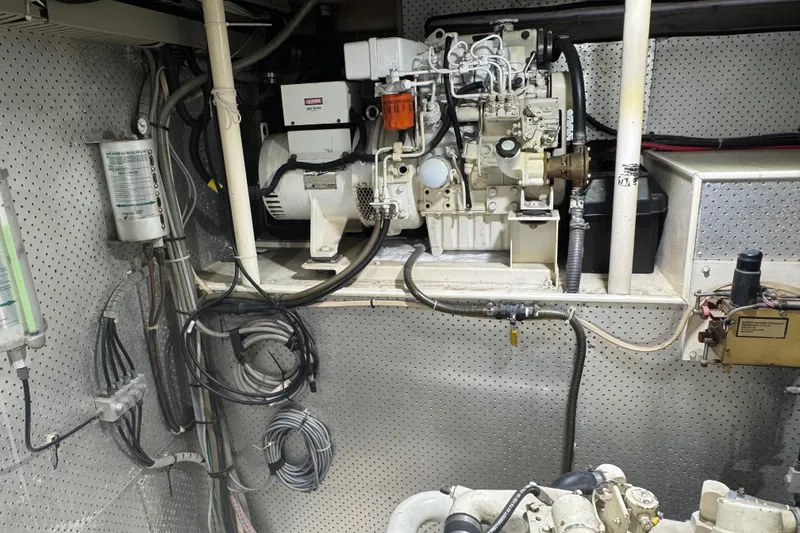 Slide: The Image of Engine room of a 1989 DeFever 54 yacht, showcasing mechanical components and wiring. - 50