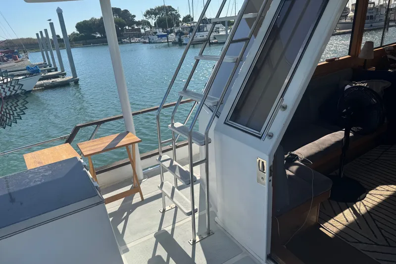 Slide: The Image of 1989 DeFever 54 yacht deck with ladder, table, and marina view. - 36