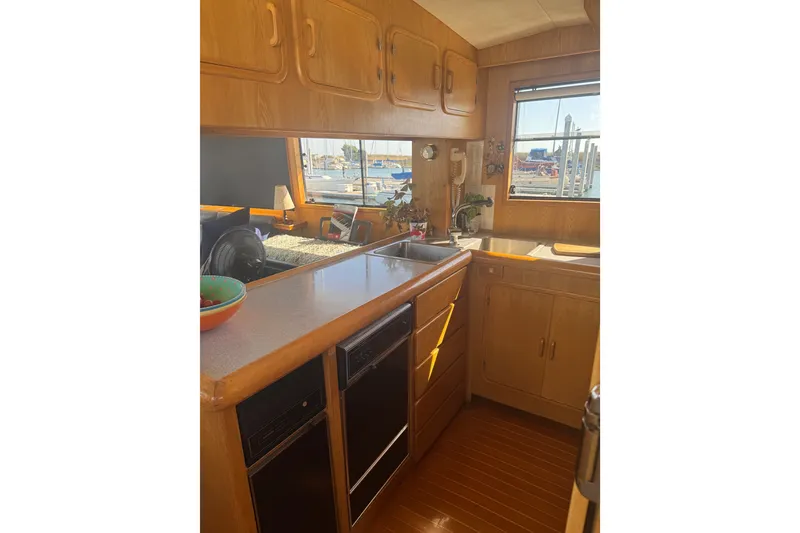 Slide: The Image of Cozy kitchen interior of 1989 DeFever 54 yacht with wooden cabinets and marina view. - 23