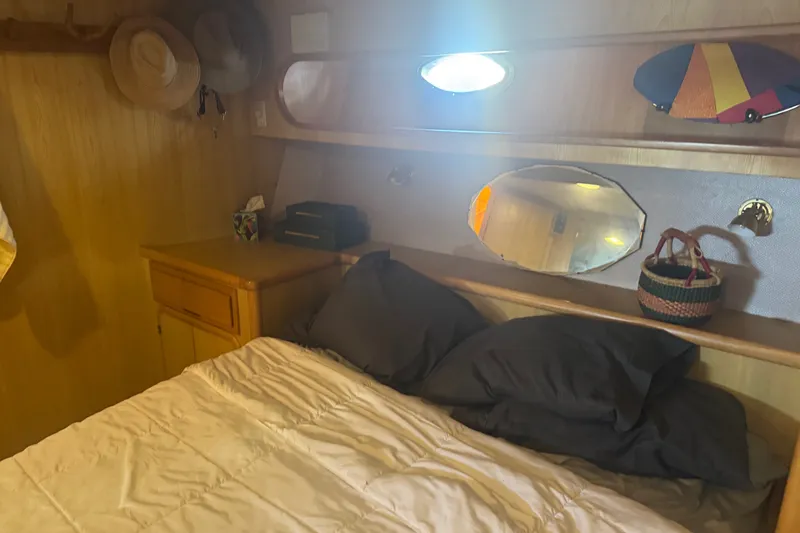Slide: The Image of Cozy cabin interior of 1989 DeFever 54 yacht with bed, pillows, and wooden cabinetry. - 20