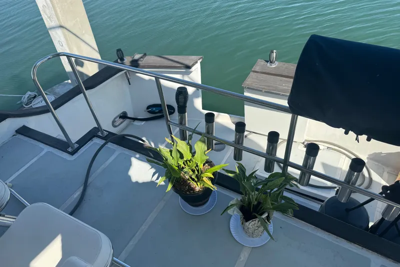 Slide: The Image of 1989 DeFever 54 yacht deck with potted plants and railing by the water. - 35