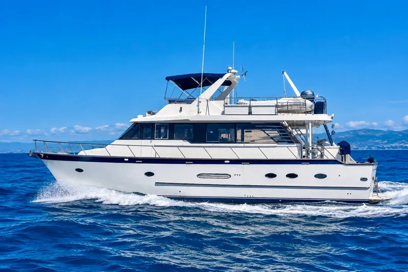 The Image of 1989 DeFever 54 yacht cruising on open blue sea under clear sky. - 0