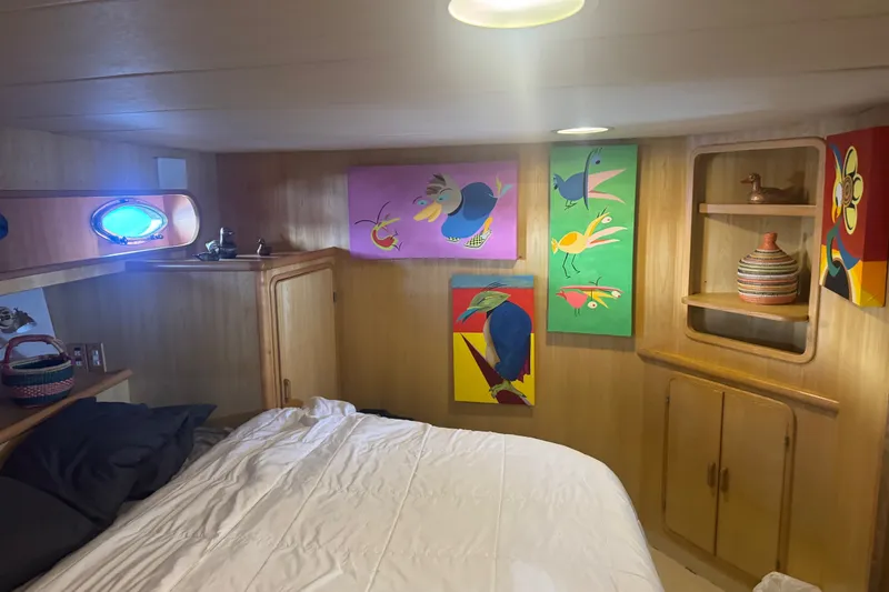 Slide: The Image of Cozy cabin interior of 1989 DeFever 54 yacht with colorful bird artwork and wooden decor. - 29