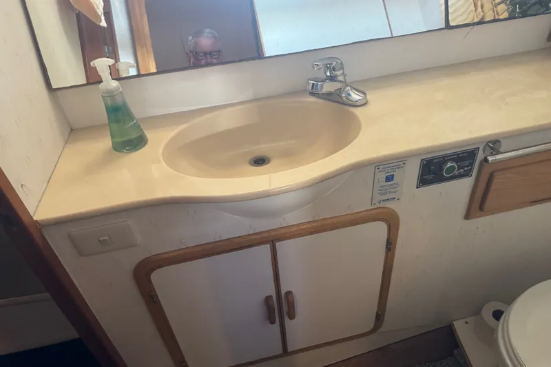 Slide: The Image of Bathroom sink area on a 1989 DeFever 54 yacht, featuring a faucet and soap dispenser. - 25