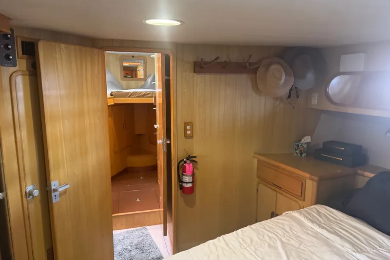Slide: The Image of Cozy cabin interior of 1989 DeFever 54 yacht with wooden furnishings and hats on hooks. - 21