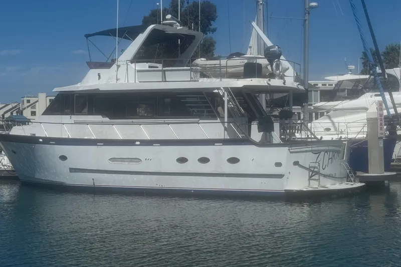 Slide: The Image of 1989 DeFever 54 yacht docked at marina, featuring classic design and spacious upper deck. - 33