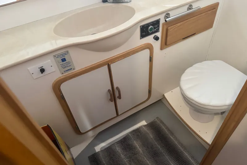 Slide: The Image of 1989 DeFever 54 yacht bathroom with sink, toilet, and wooden cabinetry. - 13