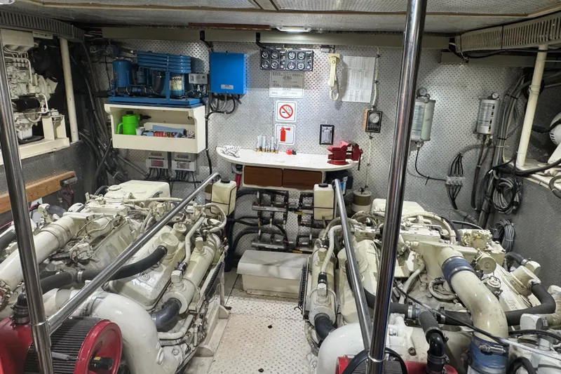 Slide: The Image of Engine room of a 1989 DeFever 54 yacht, featuring dual engines and organized equipment. - 46