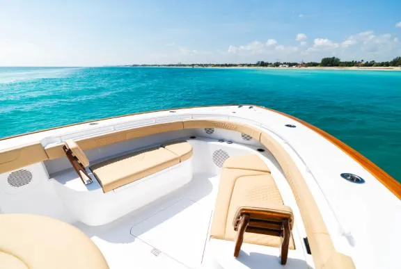 Slide: The Image of 2026 Phenom 43 Center Console boat on clear turquoise water, featuring luxurious seating. - 2