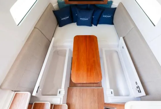 Slide: The Image of 2026 Phenom 43 Center Console interior with wooden table and blue cushions. - 8