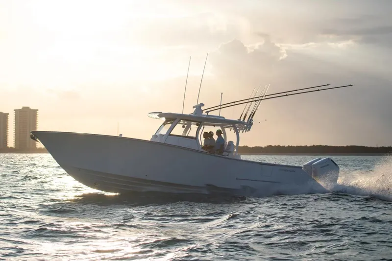 The Image of 2027 Phenom 37 Center Console boat cruising at sunset on open water. - 1