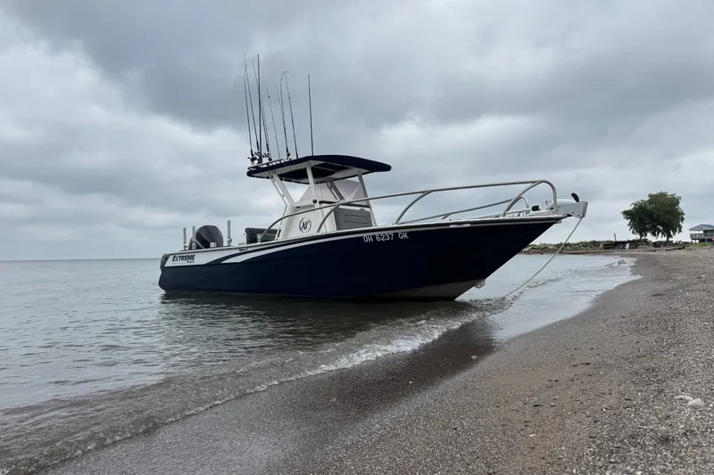 Slide: The Image of 2021 Extreme Boats 745 Center Console 24' on a sandy beach under cloudy skies. - 2