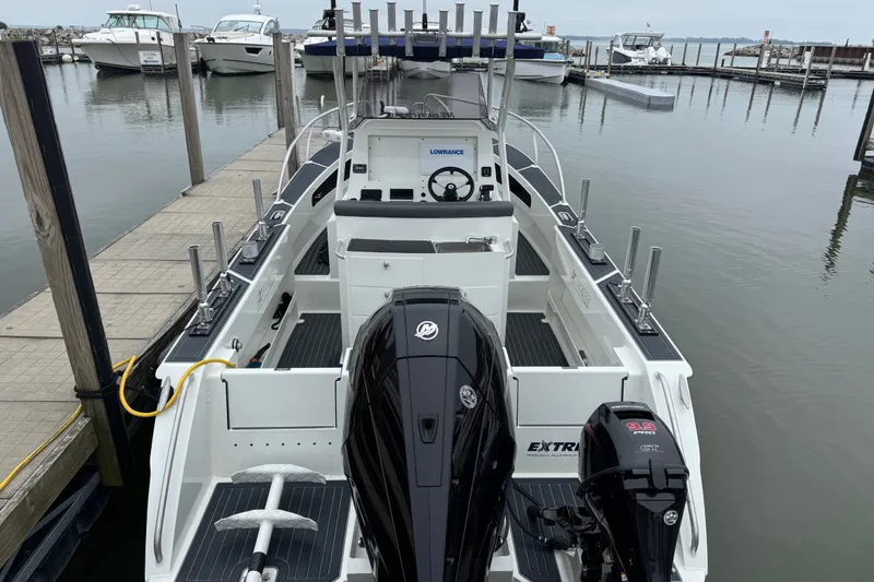 Slide: The Image of 2021 Extreme Boats 745 Center Console 24' docked, featuring dual outboard motors. - 5
