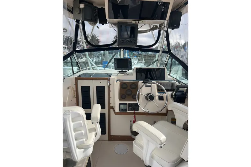 Slide: The Image of Interior view of 1996 Grady-White Gulfstream 232 boat cockpit with steering wheel and navigation equipment. - 9