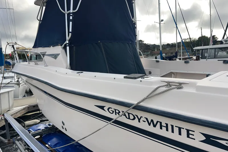 Slide: The Image of 1996 Grady-White Gulfstream 232 boat docked with blue canopy and visible branding. - 12