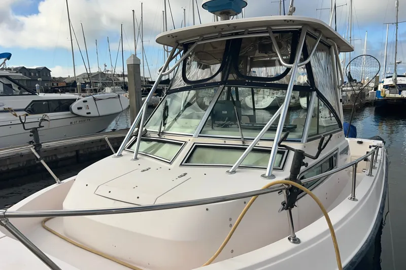 Slide: The Image of 1996 Grady-White Gulfstream 232 boat docked at marina, surrounded by other vessels. - 8