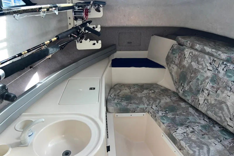 Slide: The Image of 1996 Grady-White Gulfstream 232 cabin interior with fishing rods, sink, and patterned seating. - 18