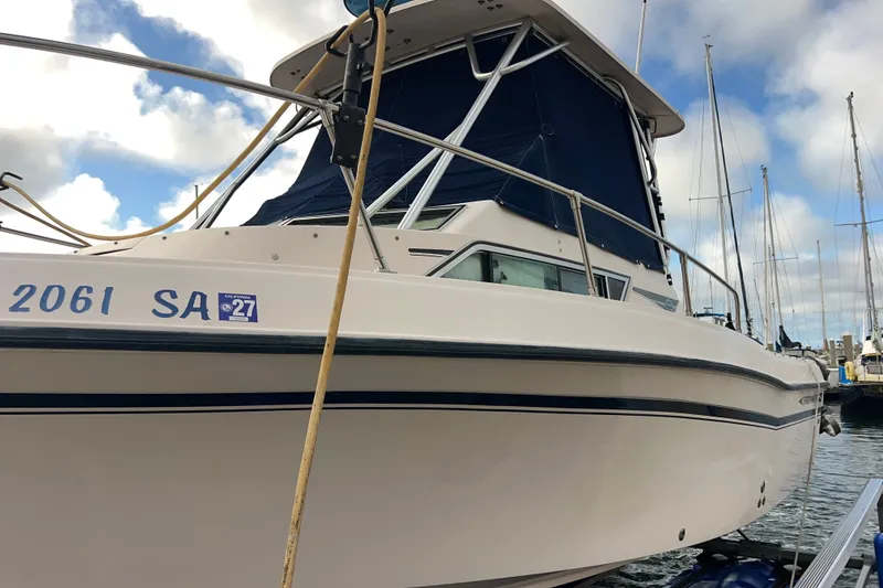 Slide: The Image of 1996 Grady-White Gulfstream 232 boat docked, featuring blue canopy and registration number. - 11