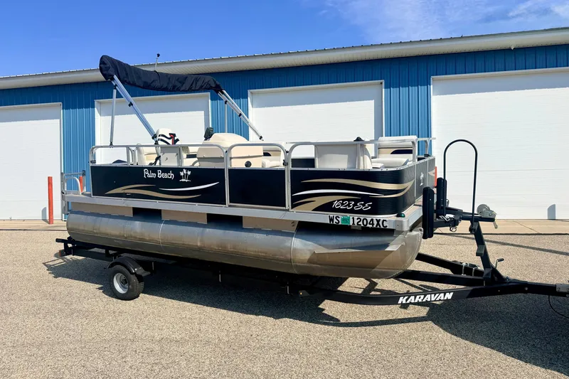 The Image of 2011 Palm Beach Sport Fish 1623 SE pontoon boat on trailer, parked outdoors. - 0