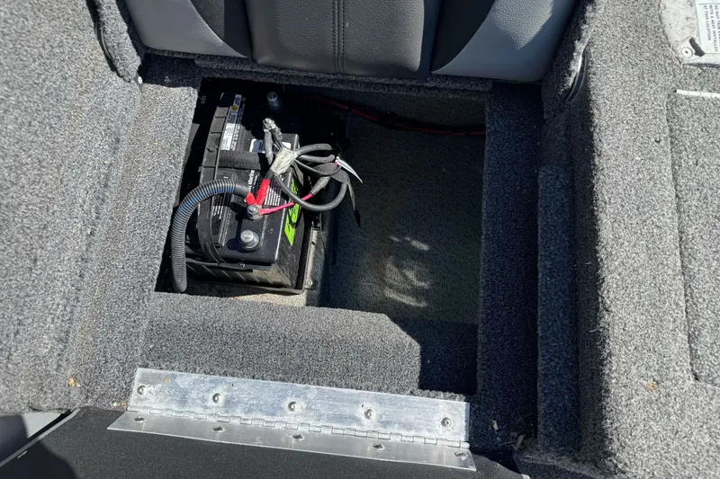 Slide: The Image of Battery compartment in 2021 Lund 1775 Crossover XS boat, featuring secure wiring and carpeted interior. - 16