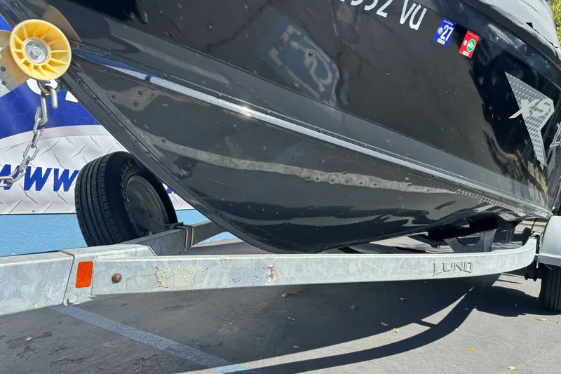Slide: The Image of 2021 Lund 1775 Crossover XS boat on trailer, close-up view of hull and wheel. - 20