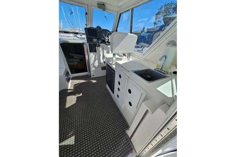 Slide: The Image of Interior of 2000 Albin 31 Tournament Express boat with helm and kitchenette. - 12
