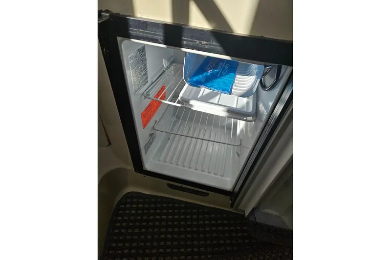 Slide: The Image of Open refrigerator inside 2000 Albin 31 Tournament Express boat, showing interior shelves and ice pack. - 22