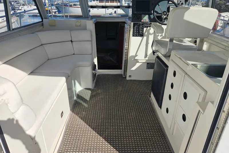 Slide: The Image of Interior of 2000 Albin 31 Tournament Express with seating, helm, and kitchenette. - 10